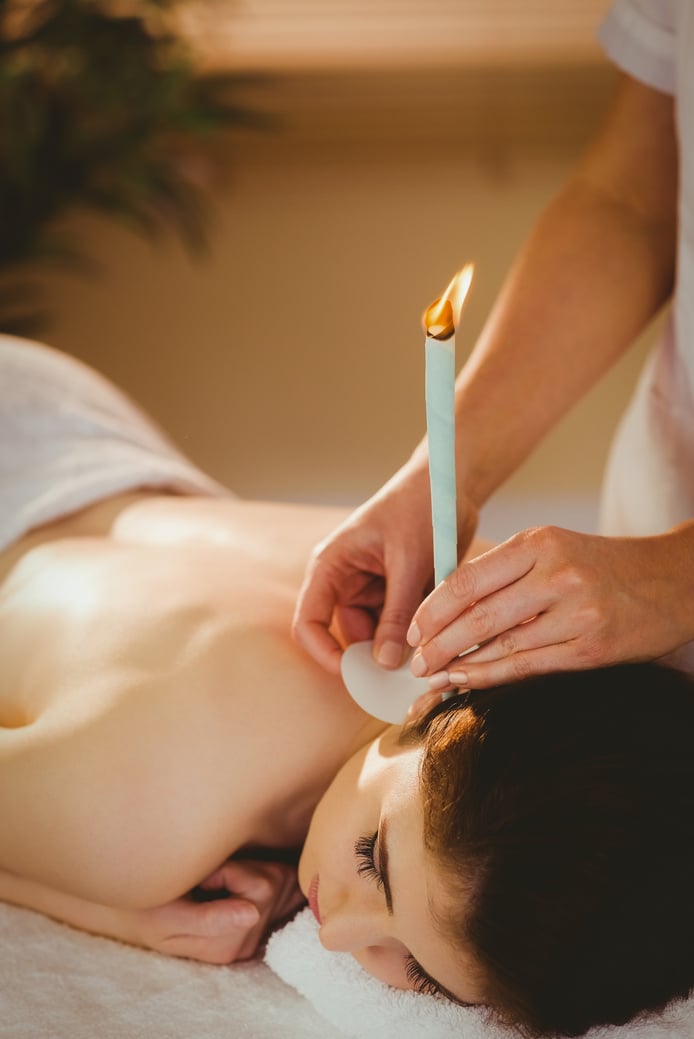 Young woman getting ear candling treatment