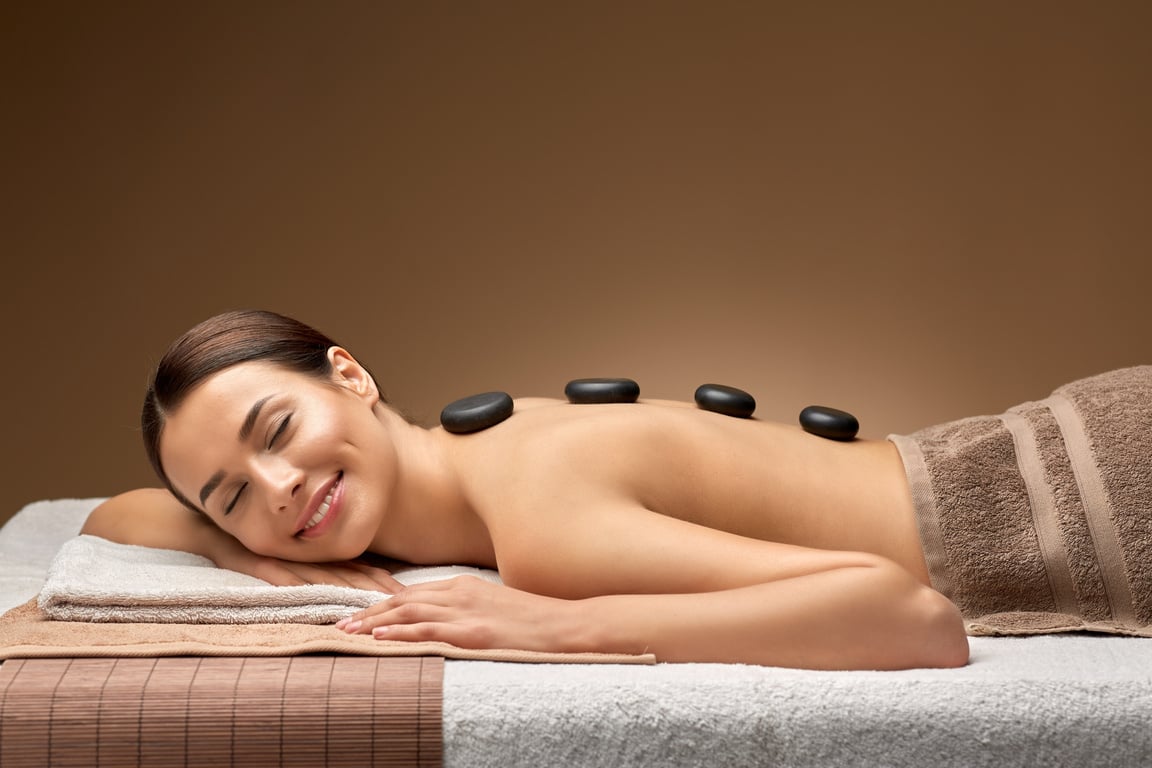 Smiling Woman Having Hot Stone Massage at Spa