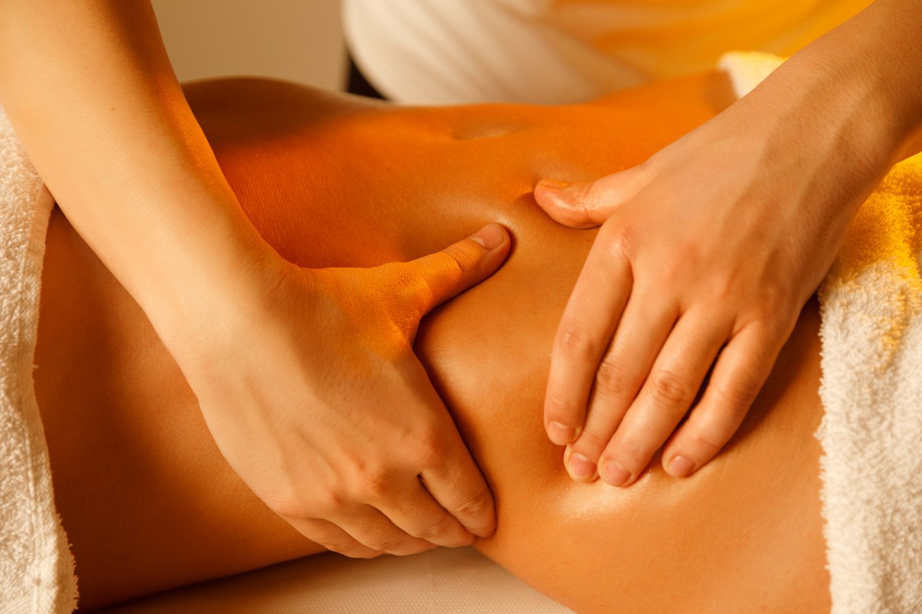 Belly massage Therapist doing healing massage. Woman enjoying in relaxing massaging at health spa treatment. Stomach massage